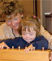 Kind mit Monika Hahn beim Arbeiten mit Montessori-Lernmaterial