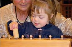 Kind mit Monika Hahn beim Arbeiten mit Montessori-Lernmaterial