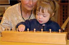 Kind mit Monika Hahn beim Arbeiten mit Montessori-Lernmaterial